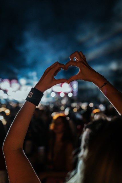 Guests forming a heart with their hands in red light